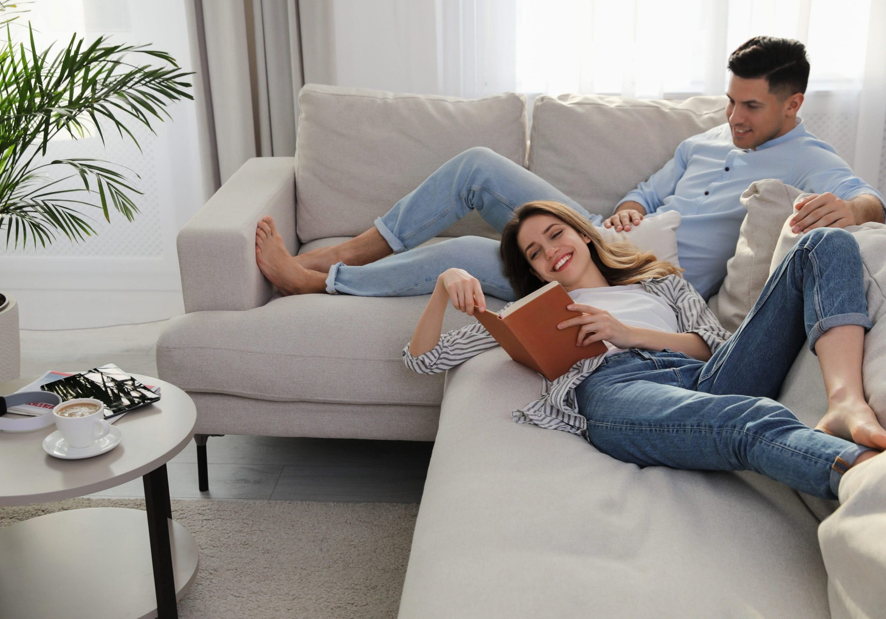 Happy couple with book on sofa in living room