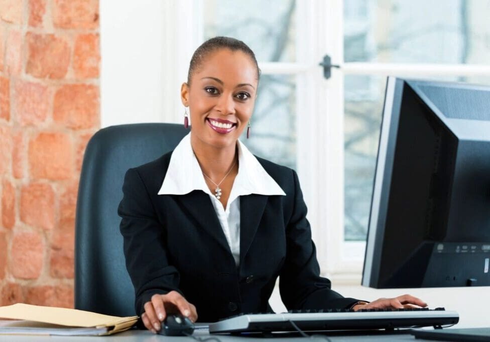 Professional woman smiling at her desk in an office.