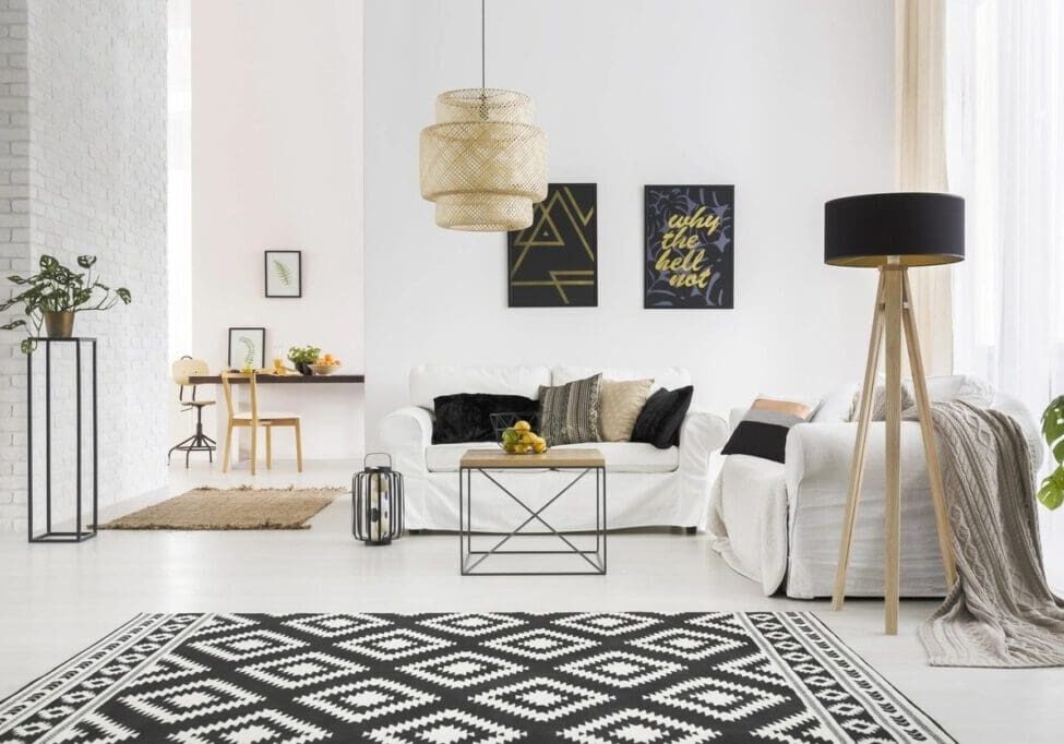 Modern living room with white furniture and patterned rug.